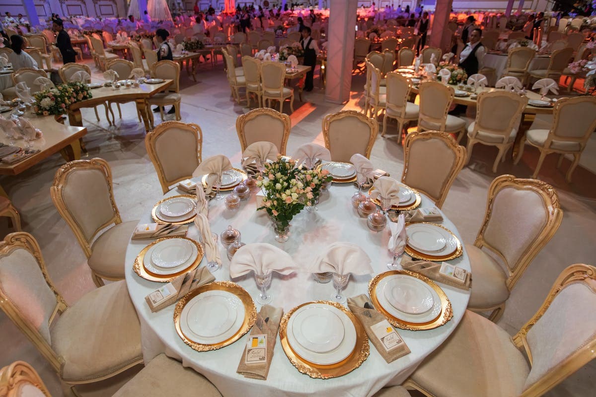 Glamour: sala bankietowa z okrągłymi stołami i złotymi talerzami